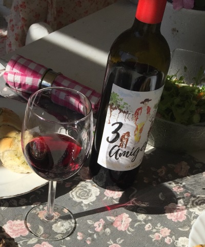 sommarbord dukat med mat och en flaska rött vin och ett glas med rött vin