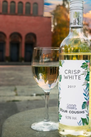 en flaska vitt vin och ett glas med hus i bakgrunden